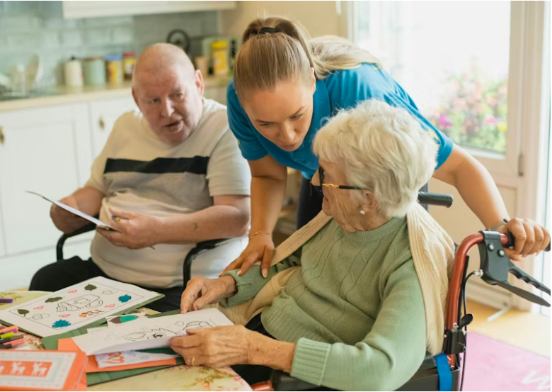 A caring nurse holding the hand of a smiling senior resident