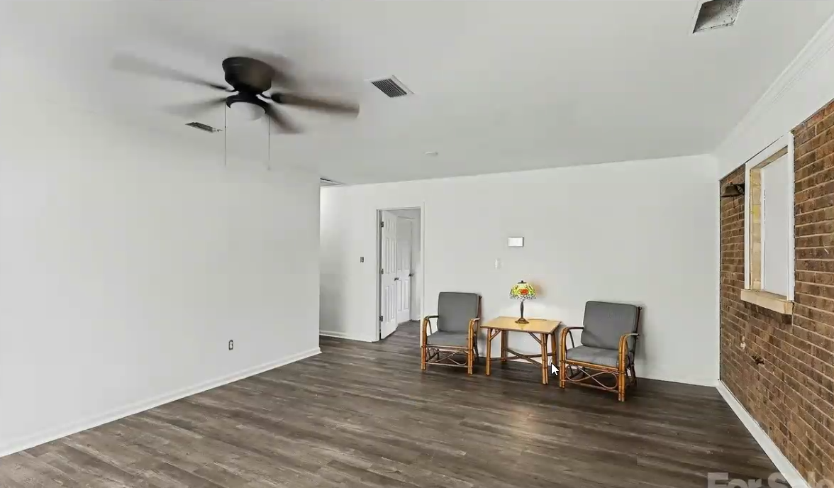 Spacious sitting area with brick accent wall